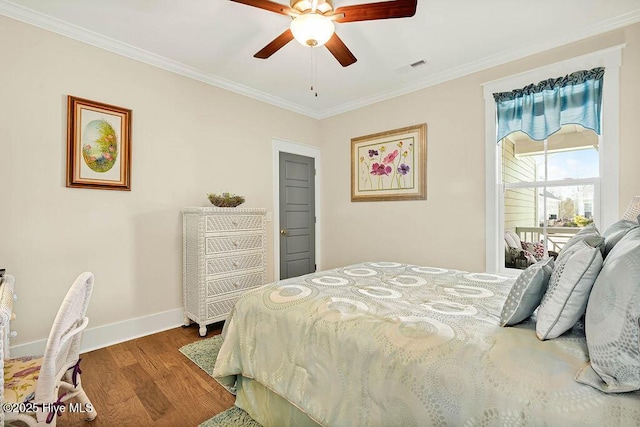 bedroom with a ceiling fan, visible vents, wood finished floors, baseboards, and ornamental molding