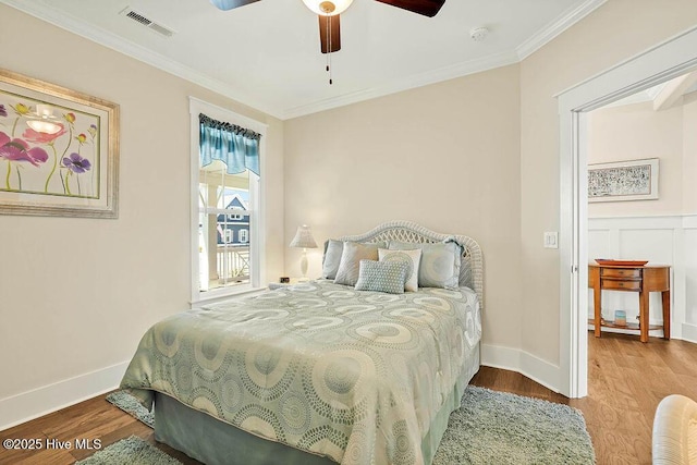 bedroom featuring crown molding, wood finished floors, and visible vents