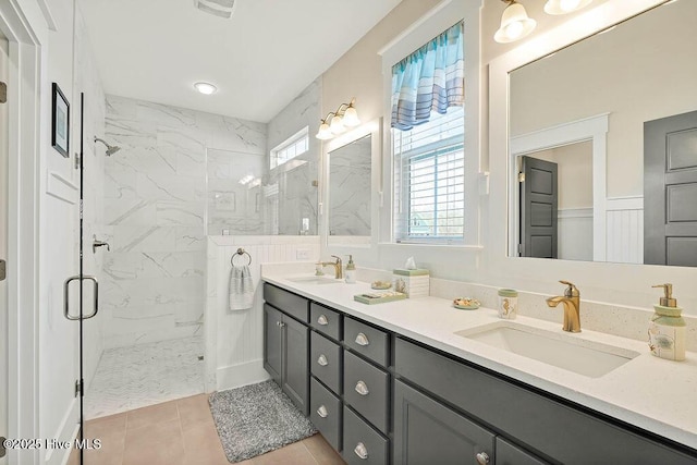 bathroom featuring double vanity, tile patterned floors, a marble finish shower, and a sink