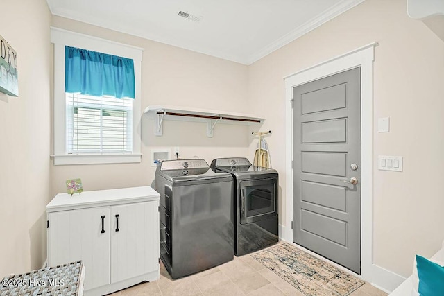 laundry room featuring crown molding, light tile patterned flooring, baseboards, visible vents, and washing machine and dryer