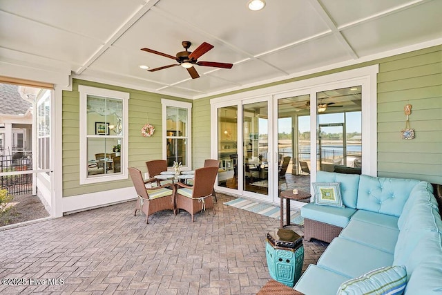 sunroom with plenty of natural light, ceiling fan, and outdoor lounge area