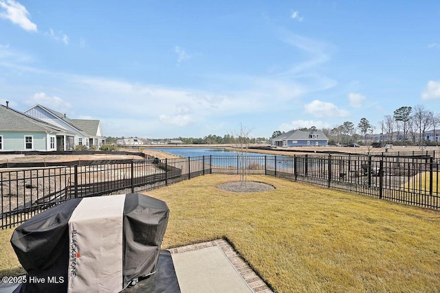 view of yard featuring a fenced backyard, a water view, and a residential view