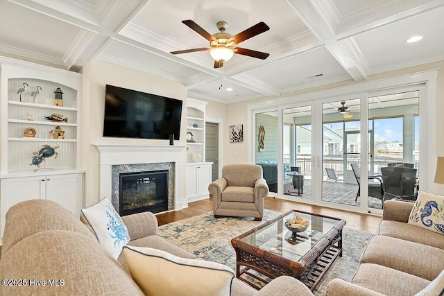 living room featuring crown molding, ceiling fan, coffered ceiling, and wood finished floors