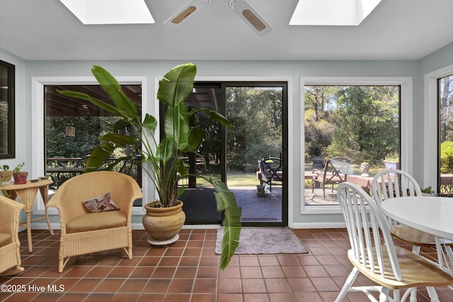 sunroom with tile patterned floors and a skylight
