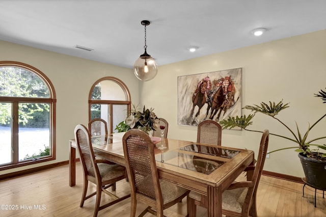 dining room with baseboards, visible vents, and light wood-style flooring