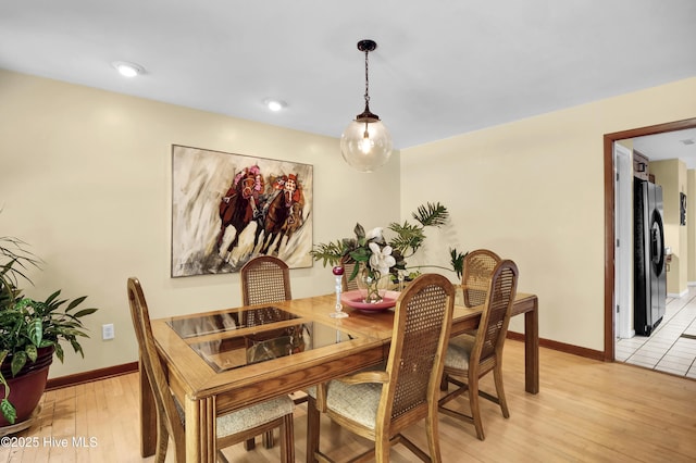dining room with baseboards and light wood-type flooring