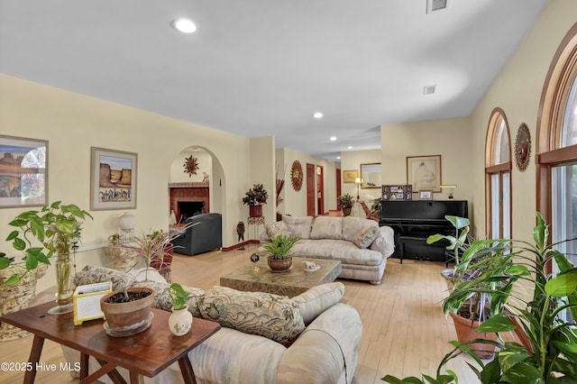 living area featuring light wood finished floors, visible vents, recessed lighting, and a fireplace