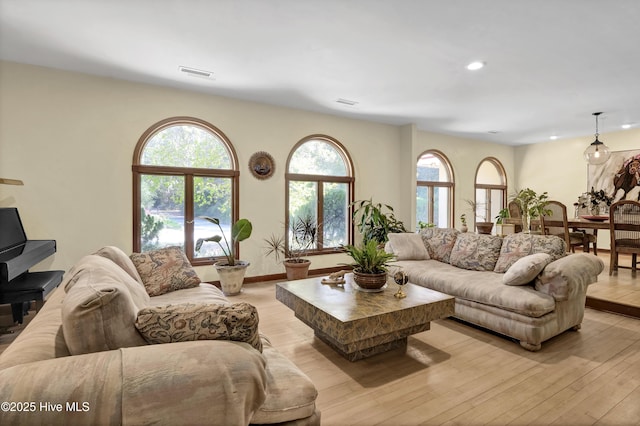 living room with baseboards, recessed lighting, visible vents, and light wood-style floors