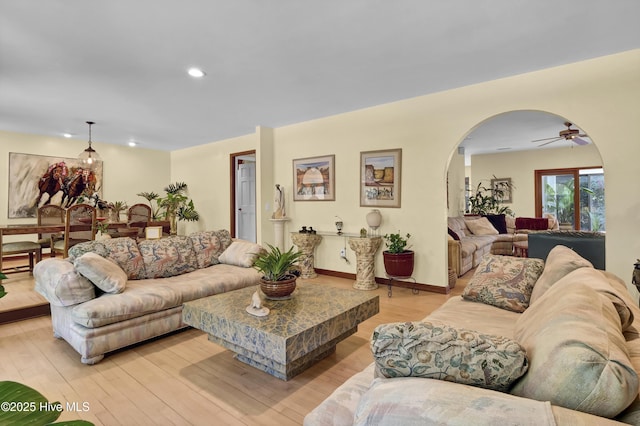 living area with light wood finished floors, baseboards, recessed lighting, a ceiling fan, and arched walkways