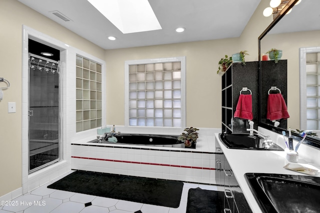 bathroom featuring a shower stall, a sink, a skylight, visible vents, and a bath