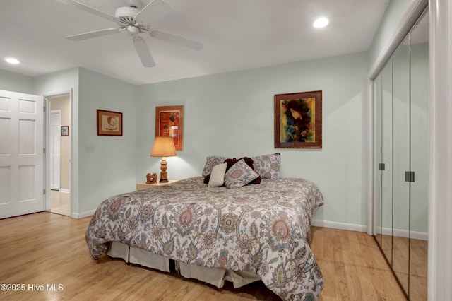 bedroom with baseboards, a closet, light wood-style floors, and a ceiling fan