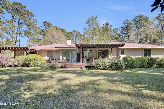 back of property featuring a wooden deck, stucco siding, a yard, and a chimney
