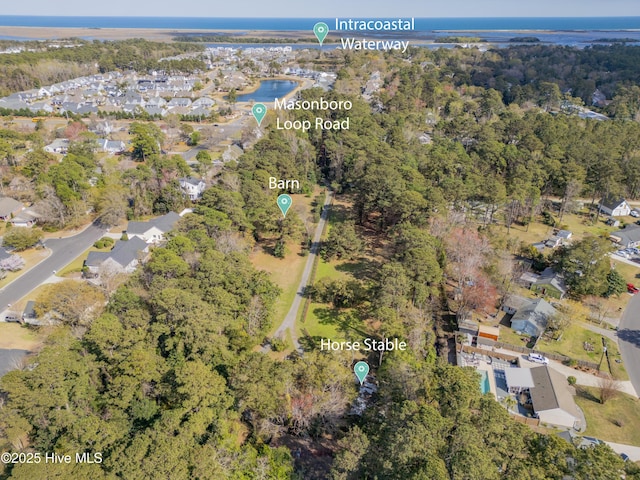 drone / aerial view featuring a forest view and a residential view