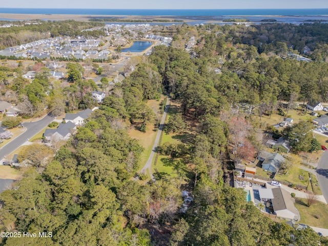 birds eye view of property with a residential view, a water view, and a view of trees