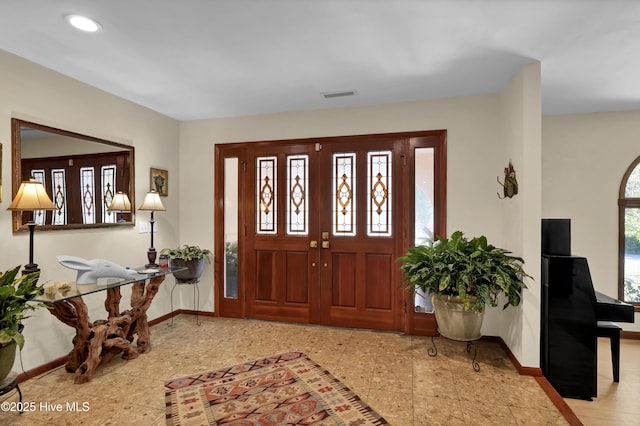 entrance foyer with a healthy amount of sunlight, baseboards, and visible vents