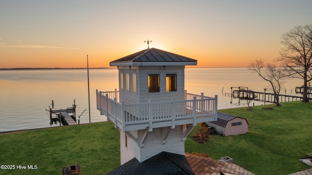 dock area featuring a lawn, boat lift, and a water view