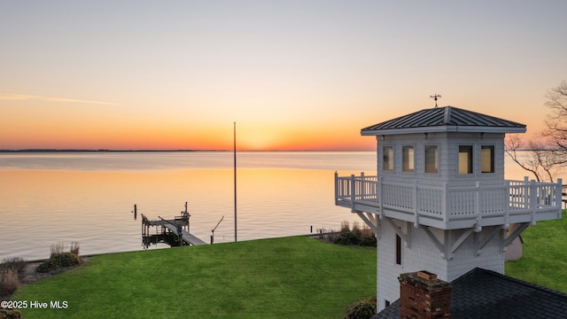 view of dock with a lawn, a water view, and boat lift