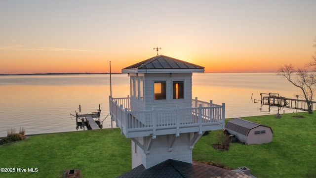 view of dock with a lawn, a deck with water view, and boat lift