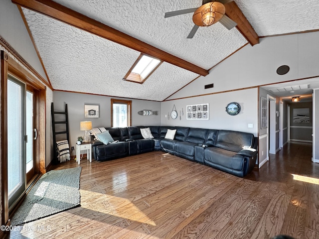 living area with lofted ceiling with beams, a textured ceiling, visible vents, wood finished floors, and ceiling fan