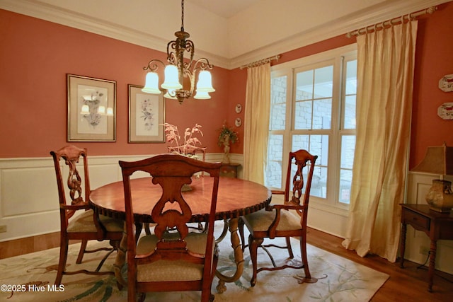 dining space with an inviting chandelier, wood finished floors, and a healthy amount of sunlight