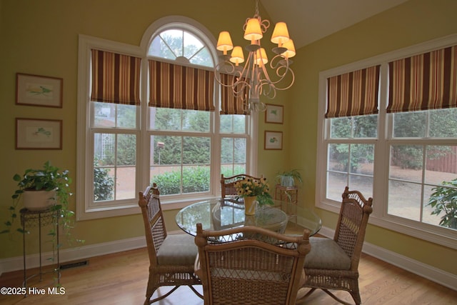 dining area with plenty of natural light, baseboards, a chandelier, and light wood-style floors