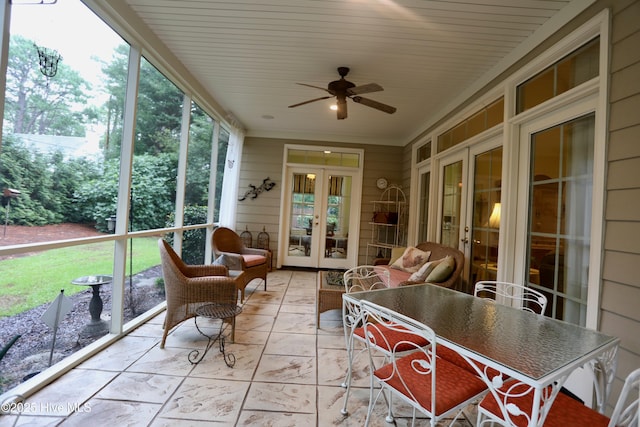 sunroom featuring outdoor dining area, ceiling fan, and french doors