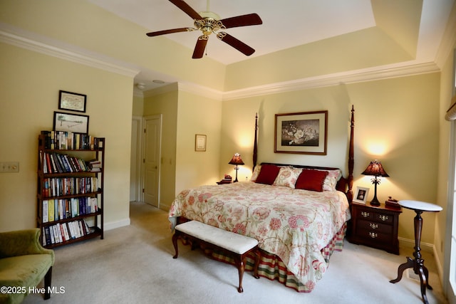 bedroom featuring a tray ceiling, baseboards, ornamental molding, and light carpet