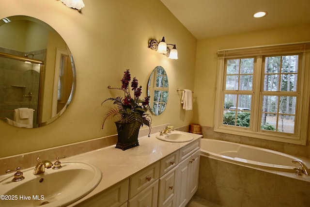 bathroom featuring double vanity, a shower stall, a bath, and a sink