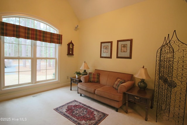 carpeted living room with visible vents and vaulted ceiling