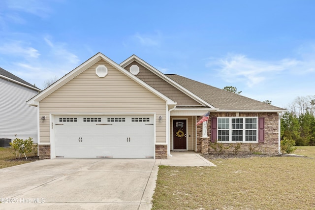 view of front of home featuring a front lawn, stone siding, a garage, and concrete driveway