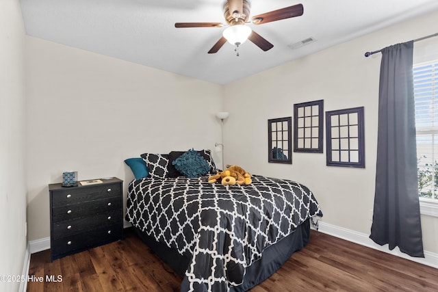 bedroom featuring wood finished floors, baseboards, ceiling fan, and visible vents