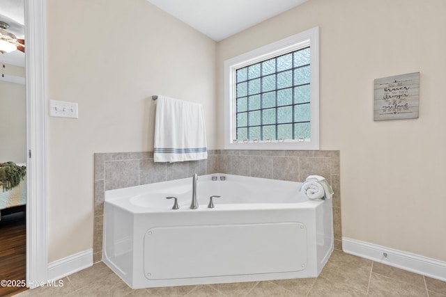 bathroom with tile patterned floors, baseboards, and a garden tub