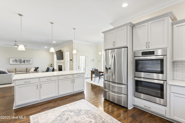 kitchen featuring dark wood-type flooring, open floor plan, stainless steel appliances, decorative backsplash, and ornamental molding
