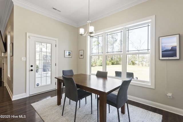 dining area with a healthy amount of sunlight, dark wood-style floors, and an inviting chandelier