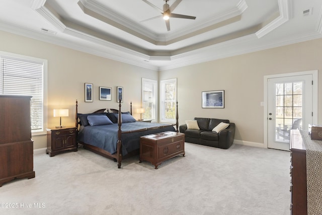 bedroom with light carpet, multiple windows, and a raised ceiling
