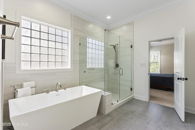 ensuite bathroom with a stall shower, a wealth of natural light, crown molding, and a freestanding tub