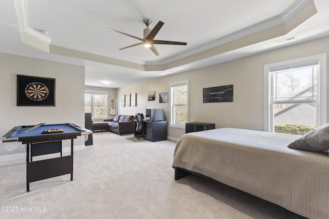 bedroom with ornamental molding, light carpet, and a raised ceiling