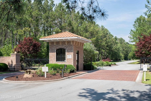view of community featuring decorative driveway and fence