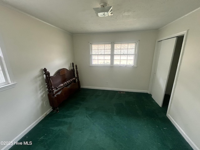 unfurnished bedroom with carpet, baseboards, and a textured ceiling