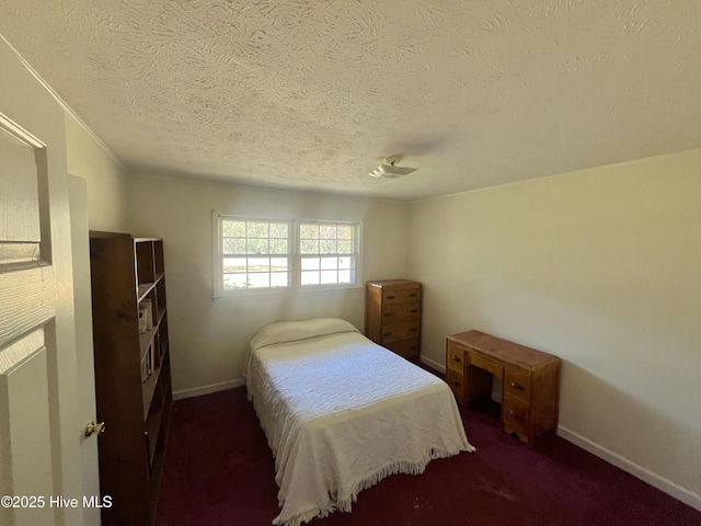 carpeted bedroom featuring a textured ceiling and baseboards