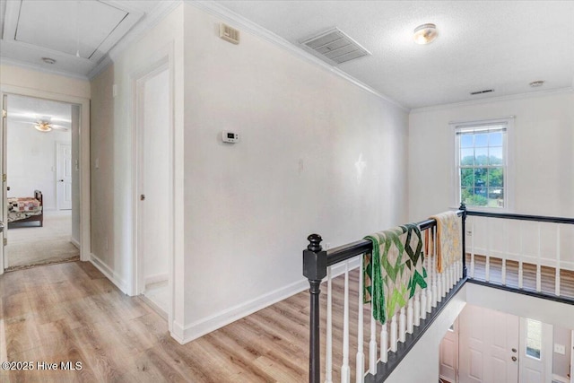 103 Roundtree Ln, Goldsboro, NC 27530 - hallway with an upstairs landing, attic access, light wood-style flooring, ornamental molding, and baseboards