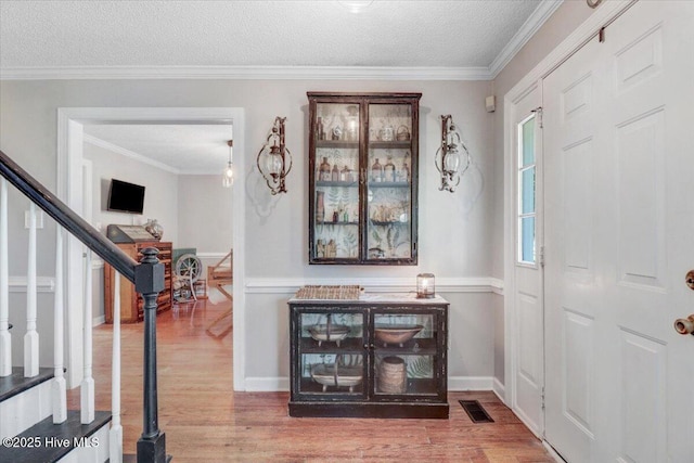 103 Roundtree Ln, Goldsboro, NC 27530 - foyer featuring wood finished floors, stairway, a textured ceiling, ornamental molding, and baseboards
