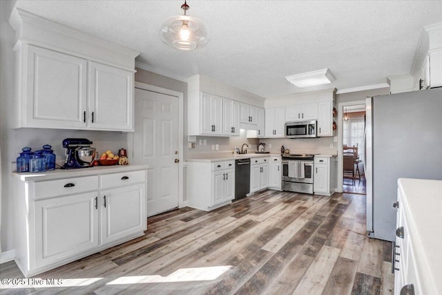 103 Roundtree Ln, Goldsboro, NC 27530 - kitchen with appliances with stainless steel finishes, a textured ceiling, light wood-type flooring, white cabinetry, and light countertops