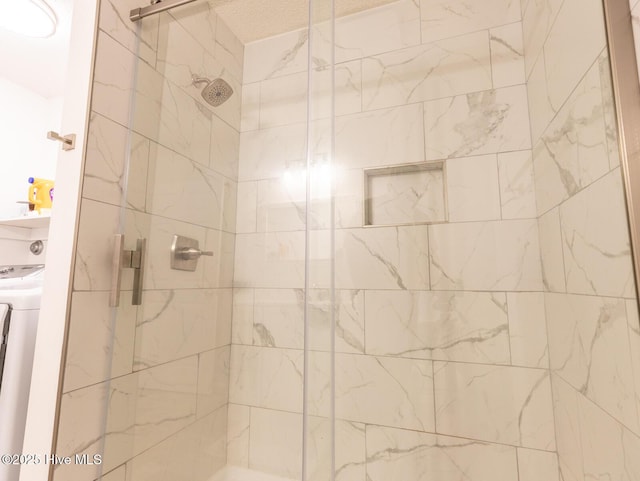 full bath featuring a stall shower and washer / dryer