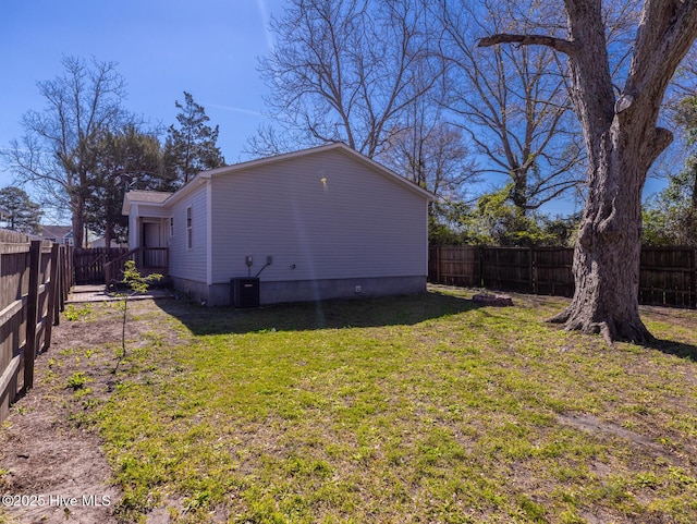 view of side of property featuring a fenced backyard, central air condition unit, and a yard