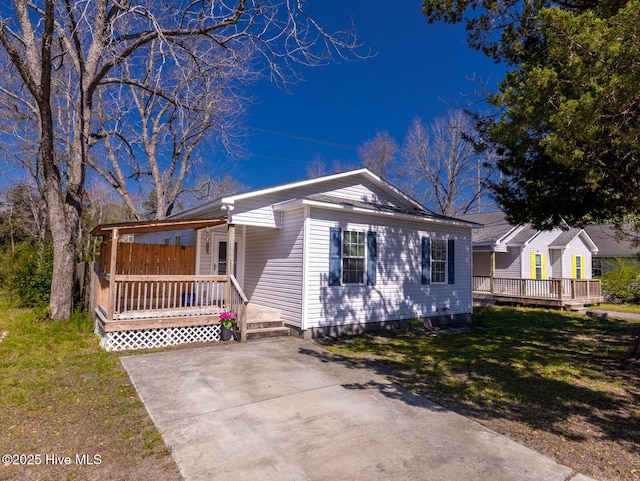 view of front facade featuring a front lawn and a wooden deck