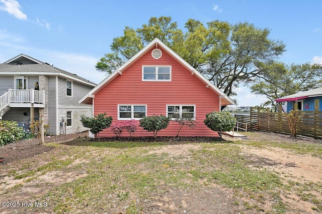 rear view of property with fence and a lawn
