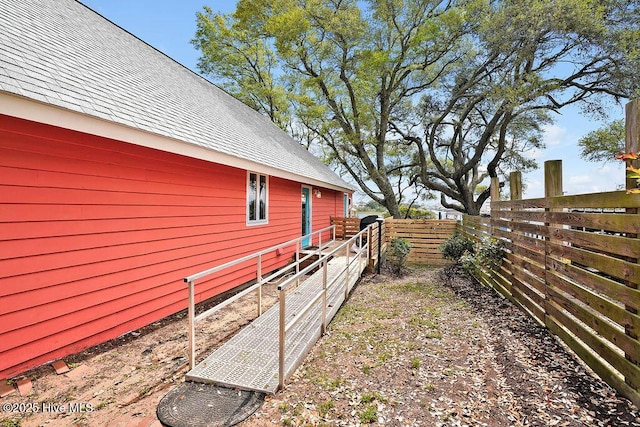 view of home's exterior featuring a fenced backyard and roof with shingles