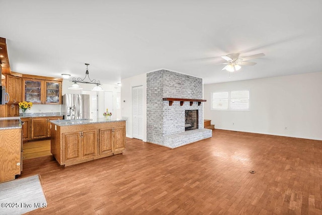 kitchen featuring open floor plan, light wood-style floors, appliances with stainless steel finishes, and a ceiling fan