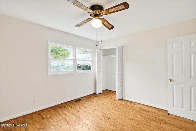 unfurnished bedroom with light wood-type flooring, a closet, baseboards, and visible vents